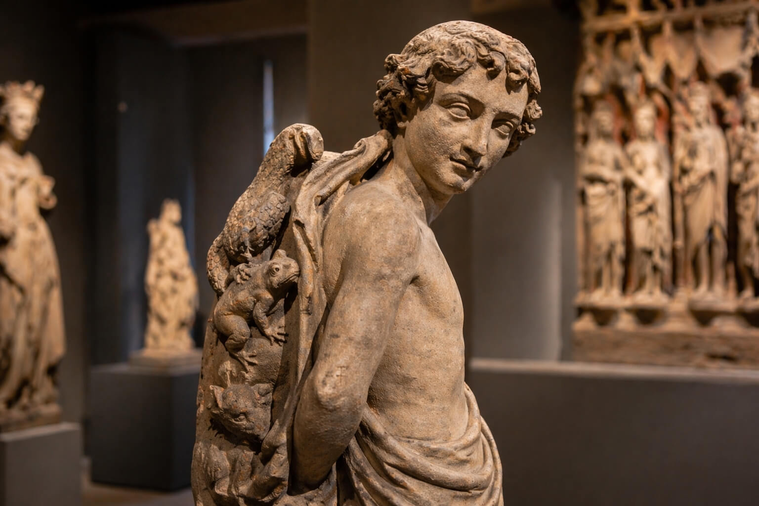 Gros plan sur une sculpture gothique exposée au musée, avec des détails sculptés très expressifs.