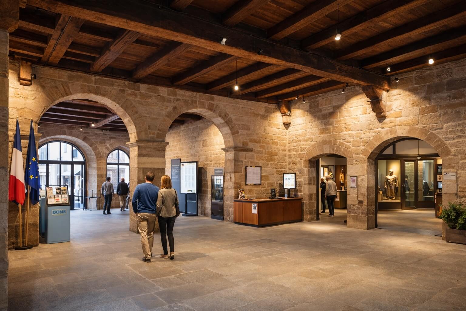 Ambiance intérieure du musée avec architecture ancienne restaurée et visiteurs découvrant les premières salles.