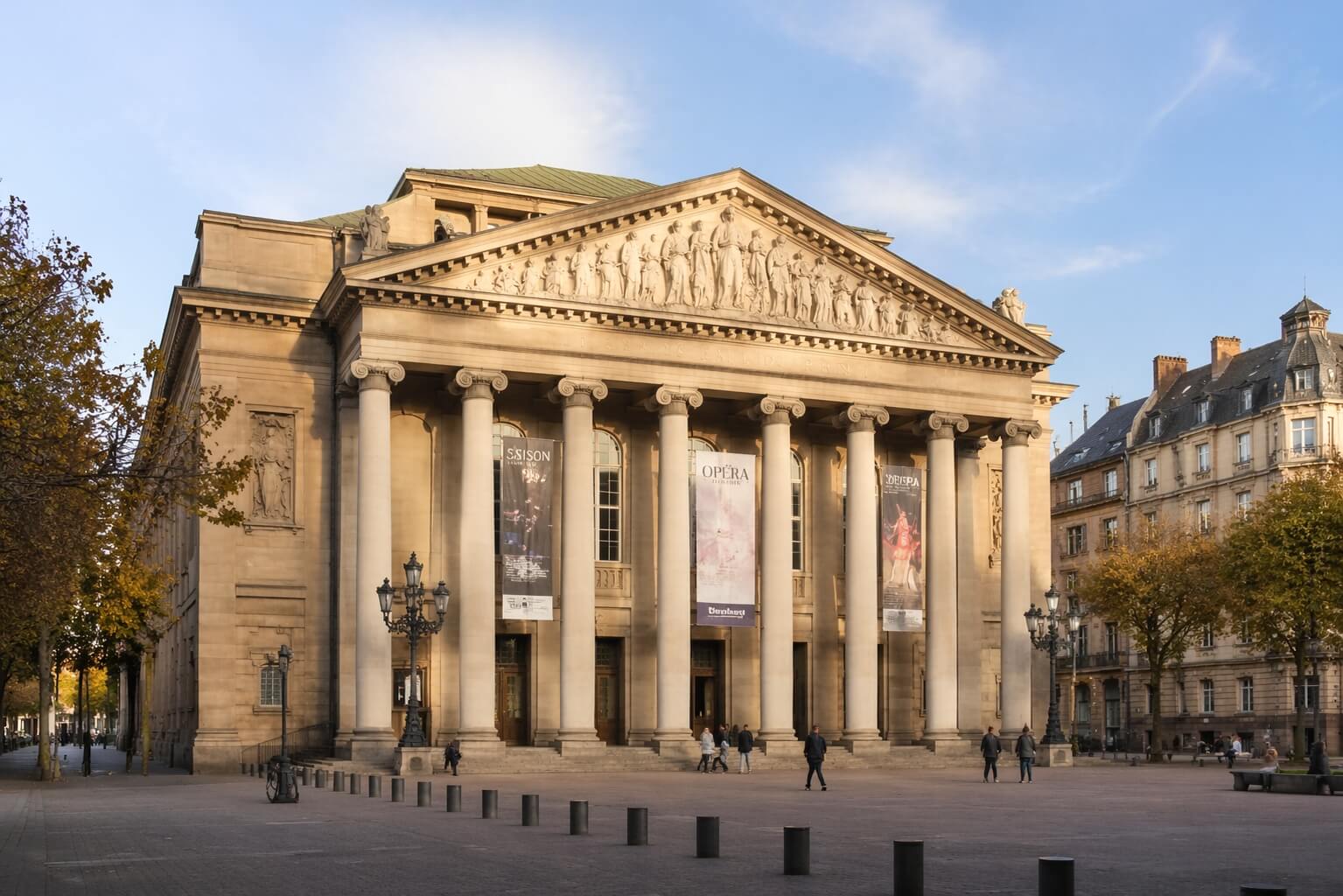 Vue en format paysage de la façade néoclassique de l’Opéra national du Rhin à Strasbourg, sur la place Broglie, avec ses grandes colonnes et son élégance monumentale.