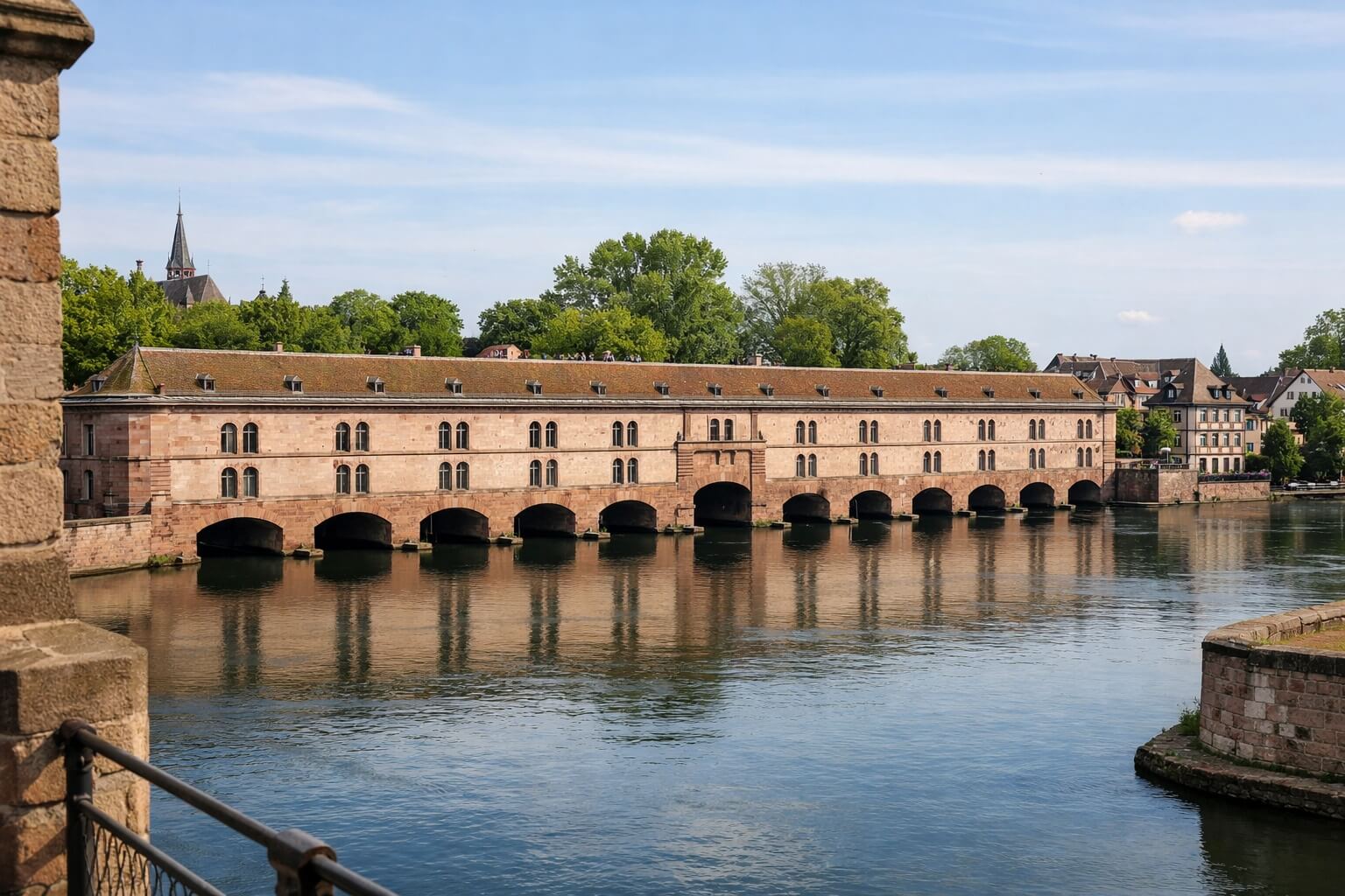 Vue du Barrage Vauban à Strasbourg depuis les Ponts Couverts, avec sa longue façade en grès rose au bord de l’eau.