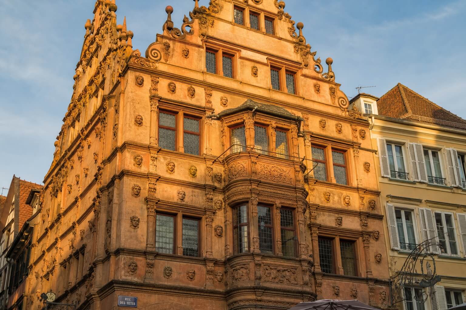 Façade de la Maison des Têtes à Colmar avec ses nombreuses sculptures de visages et son oriel typique de la Renaissance