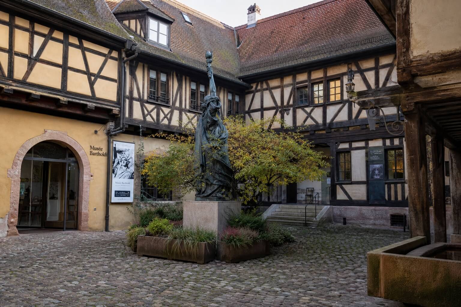 Cour intérieure du musée Bartholdi à Colmar avec sculpture monumentale et architecture alsacienne traditionnelle