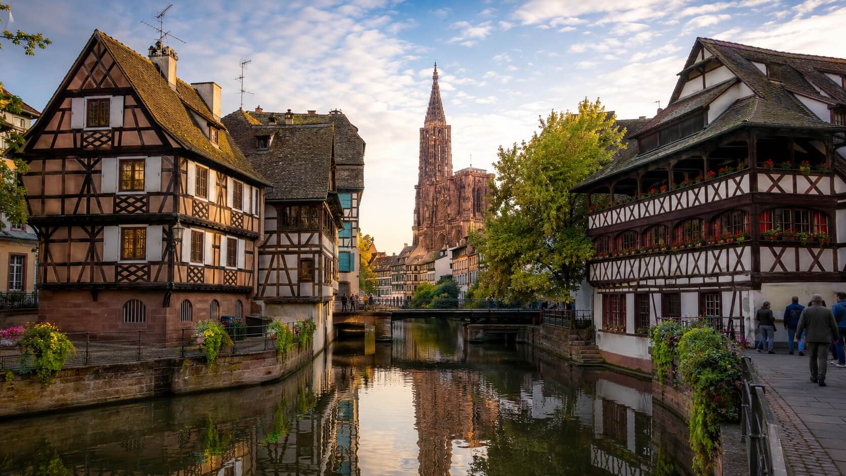 Vue lumineuse de Strasbourg avec la cathédrale Notre-Dame, les maisons à colombages de la Petite France et les canaux de l’Ill lors d’une journée de visite.