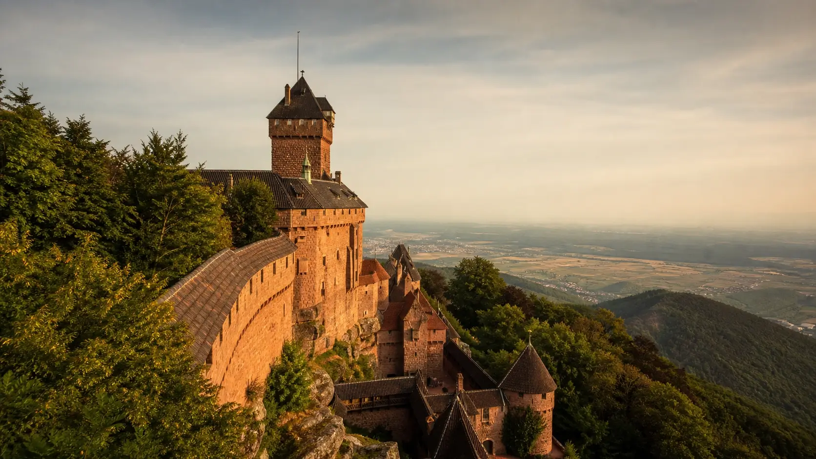 Vue du château du Haut-Kœnigsbourg entouré de forêt avec panorama sur la plaine d’Alsace