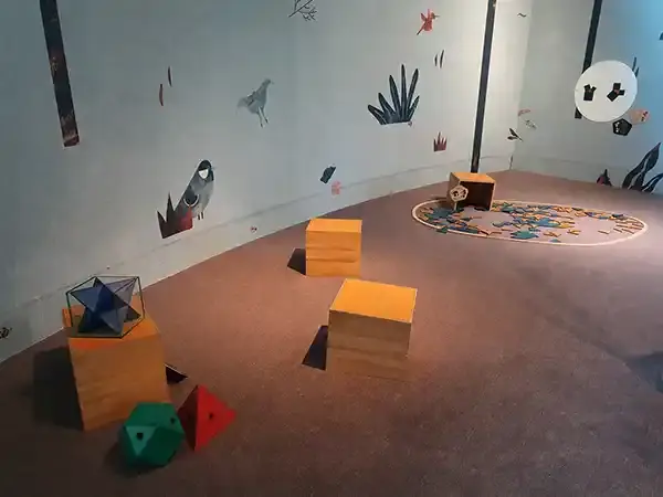 Espace ludique du Vaisseau à Strasbourg avec des modules en bois, des objets colorés et une fresque murale sur le thème de l’espace, photographié en 2023.